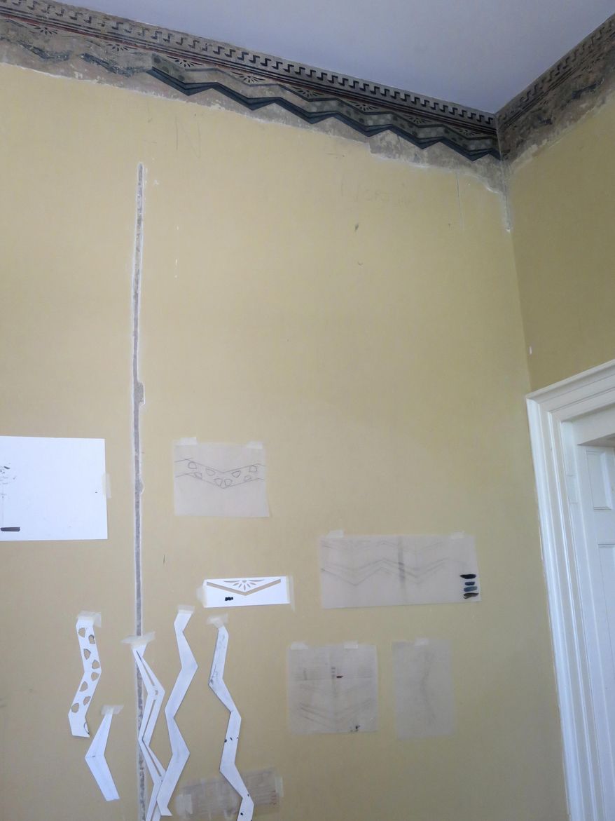 This Aug. 20, 2016 photo shows a detail of a decorative wall border, and paper stencils being used in their restoration at the home of artist Thomas Cole, in Catskill, N.Y. Not only did Cole paint lush mountain landscapes that inspired the Hudson River School art movement of the 19th century, he also painted on the walls of his home in Catskill. The decorative patterns near the ceiling lines, hidden under layers of paint for more than a century and discovered a few years ago, will be fully displayed when the Thomas Cole National Historic Site opens for the season in May 2017. (AP Photo/Barbara Woike)