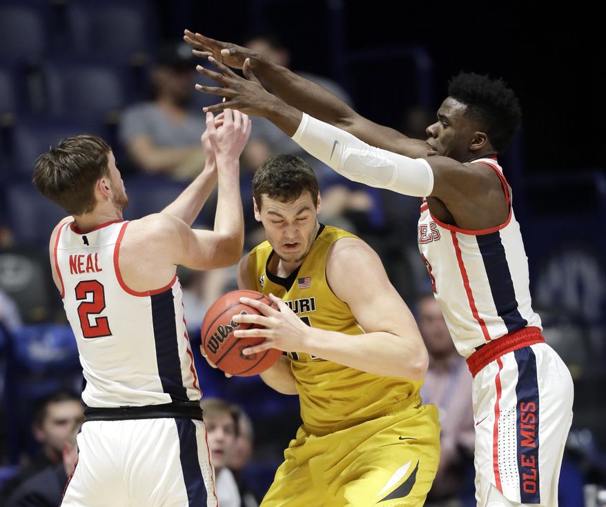 Missouri forward Reed Nikko, center, tries to get away from Mississippi defenders Cullen Neal (2) and Terence Davis, right, during the first half of an NCAA college basketball game at the Southeastern Conference tournament Thursday, March 9, 2017, in Nashville, Tenn. (AP Photo/Wade Payne)