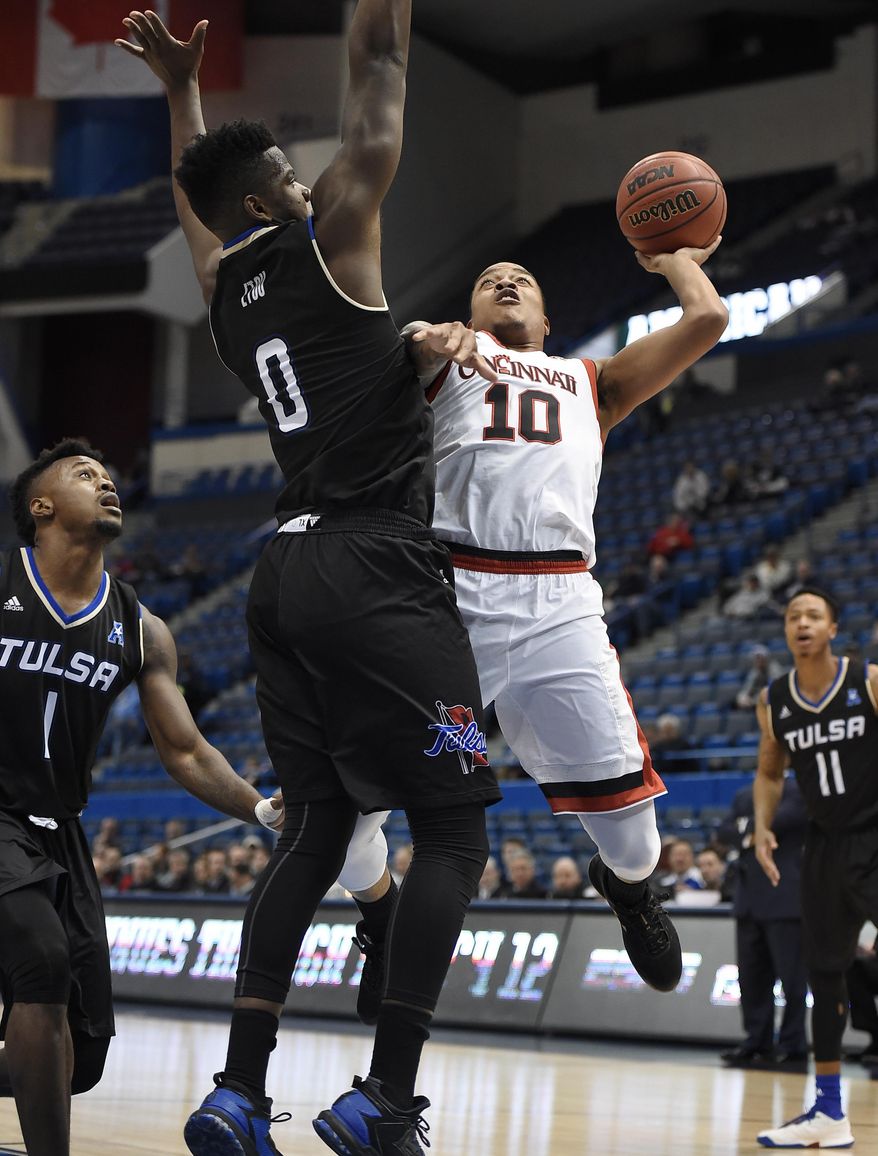 Cincinnati&#39;s Troy Caupain shoots as Tulsa&#39;s Junior Etou, left, defends during the first half of an NCAA college basketball game in the American Athletic Conference tournament quarterfinals, Friday, March 10, 2017, in Hartford, Conn. (AP Photo/Jessica Hill)