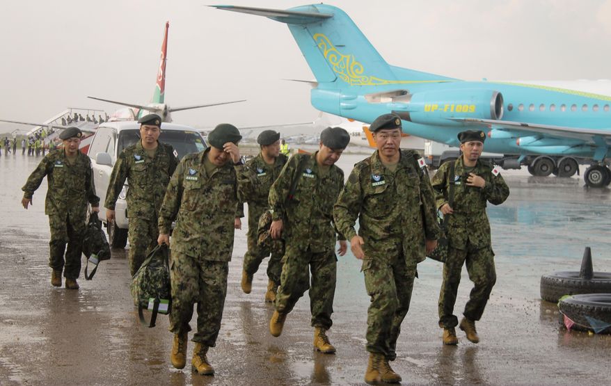 FILE - In this Nov. 21, 2016 file photo, members of the Japan Self-Defense Forces walk upon arrival as part of a first batch who have a broader mandate to use force at the airport in Juba as Japanese peacekeepers landed in South Sudan in the first such deployment of the country's troops overseas with those expanded powers in nearly 70 years. The Japanese government has decided to end its peacekeeping mission in South Sudan after five years. Prime Minister Shinzo Abe said Friday, March 10, 2017, that Japan will not renew the mission after the current rotation returns in May. The 350-person infrastructure team was focused on road construction. (AP Photo/Justin Lynch, File)