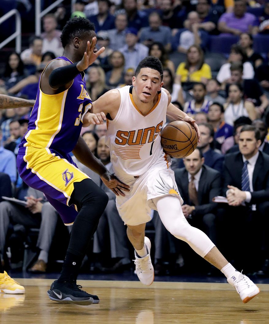 Phoenix Suns guard Devin Booker (1) drives against Los Angeles Lakers forward Julius Randle during the second half of an NBA basketball game, Thursday, March 9, 2017, in Phoenix. (AP Photo/Matt York)