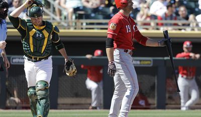 Oakland Athletics&#x27; Stephen Vogt walks to the dugout as Cincinnati Reds&#x27; Joey Votto reacts to striking out during the first inning of a spring training baseball game Thursday, March 9, 2017, in Mesa, Ariz. (AP Photo/Darron Cummings)