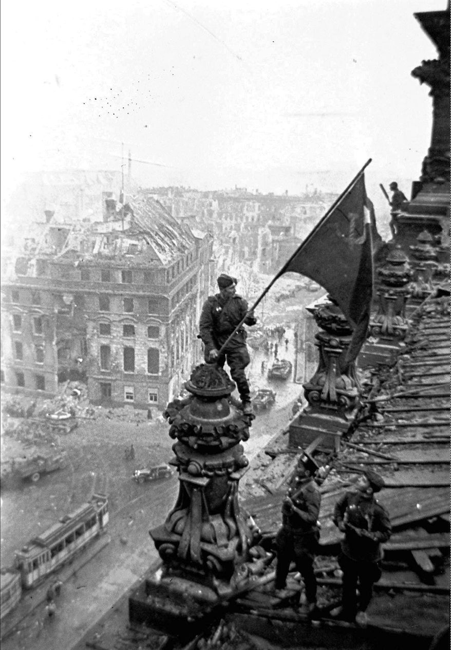 FILE- In this May 2, 1945 file photo, Soviet soldiers hoist the red flag over the Reichstag after the fall of Berlin, which is one of the iconic images of World War II taken by renowned photographer Yevgeny Khaldei. Just days before the 100th anniversary of Yevgeni Khaldei's birth, the daughter of the photographer who took the iconic WWII image of Red Army soldiers atop the Reichstag, Anna Khaldei has regained possession of his original negatives after a 15-year court battle and is now hoping to mount an exhibition of her father's work, recording history through his lens. (Yevgeny Khaldei/iTAR-TASS file photo via AP)