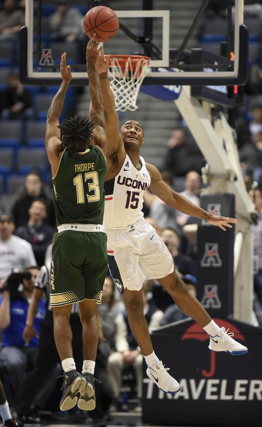 Connecticut guard Rodney Purvis (15) blocks on a shot by South Florida guard Geno Thorpe (13) during the first half of the first round of the American Athletic Conference basketball tournament in Hartford, Conn., Thursday, March 9, 2017. (John Woike Hartford Courant via AP)