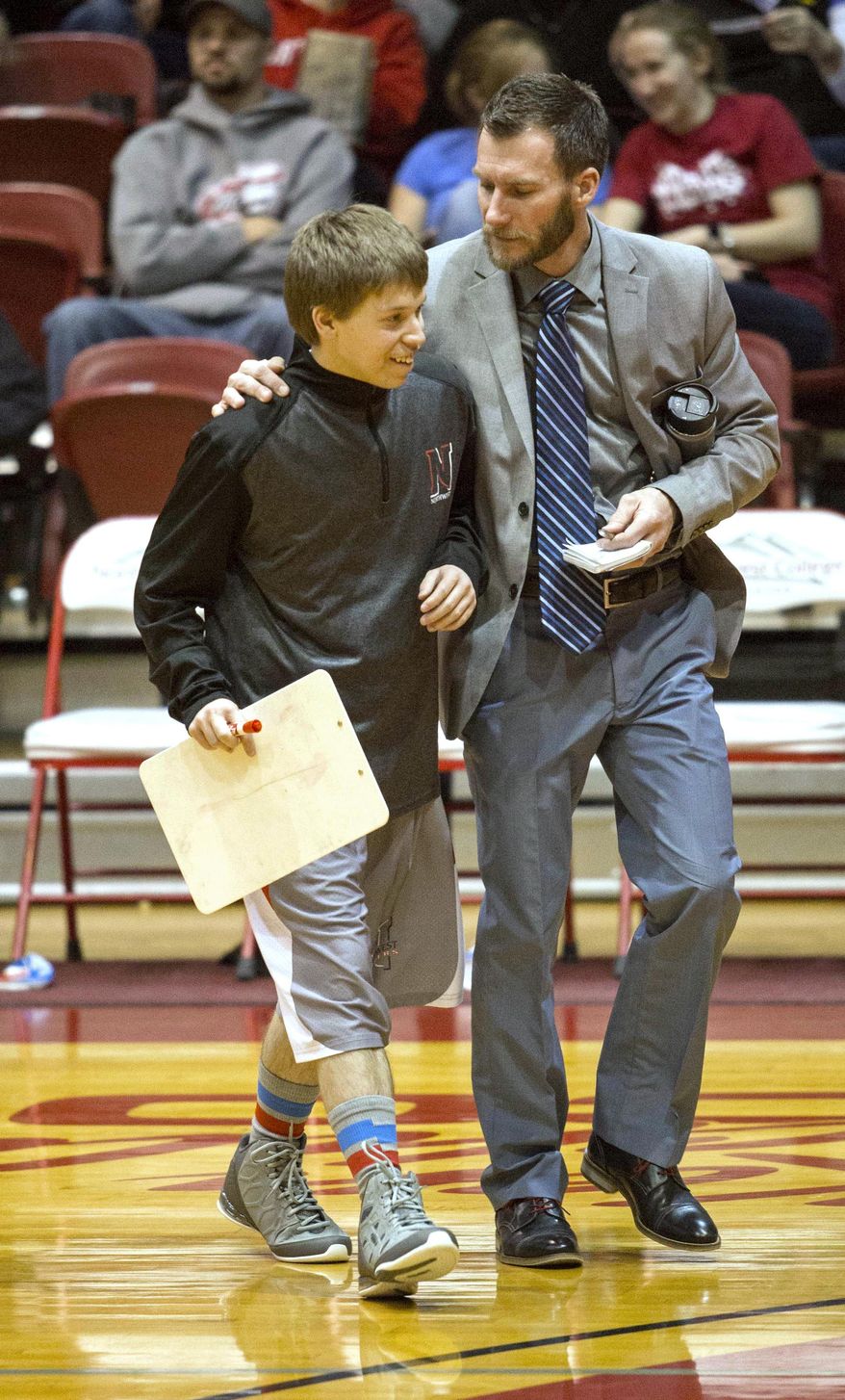 Student assistant coach Robbie Nowak was promoted to "honorary head coach" for Northwest College's win over Little Big Horn College on Thursday, Feb. 9, 2017 in Powell, Wyo. He's pictured with assistant coach Greg Bennett. (Chelsea Blake /The Cody Enterprise via AP)