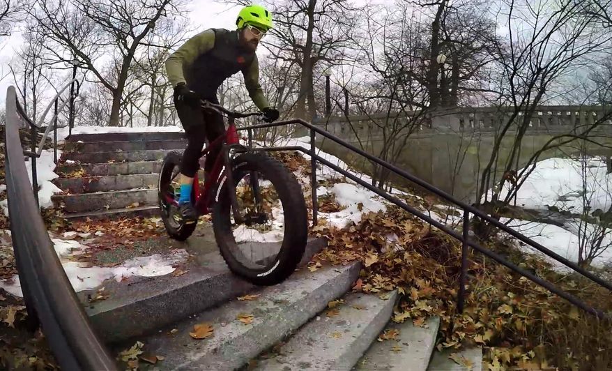 In this Friday, Feb. 24, 2017 photo Range Morton rides down a stairway on his fat tire bike at a park in Portland, Maine. The ginormous tires are wide enough to roll over snow and sand that would bog down a normal bike. (AP Photo/Robert F. Bukaty)