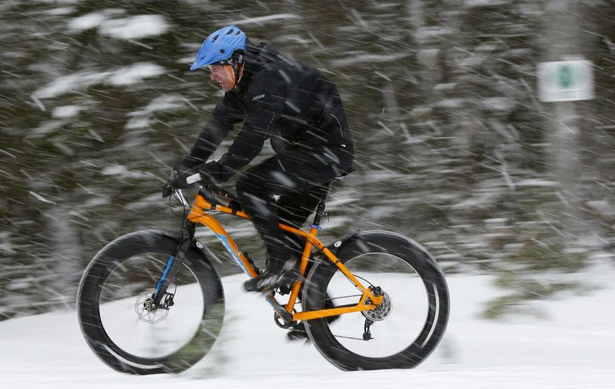In this Saturday, Feb. 11, 2017 photo a fat tire bicyclist rides on a cross country ski trail during a race at the Sugarloaf ski resort in Carrabassett Valley, Maine. The mountain bikes with comically large tires have been around for a decade, but they've come into the mainstream in the past five years. Research firm The NPD Group says sales have grown eightfold over the past three years. (AP Photo/Robert F. Bukaty)