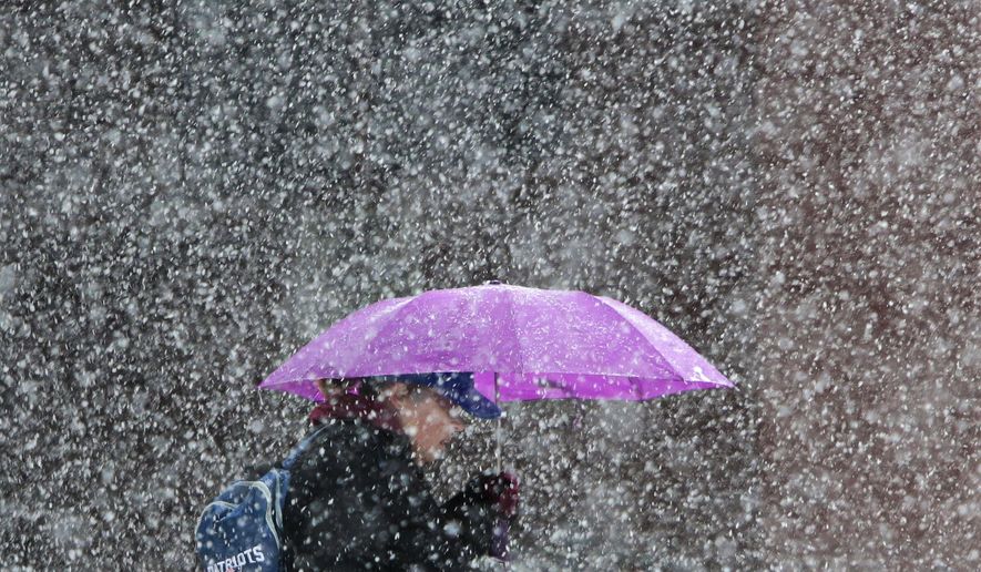 A woman walks down the street during a snow storm in New Bedford, Mass., on Friday, March 10, 2017. (Peter Pereira/Standard Times via AP)