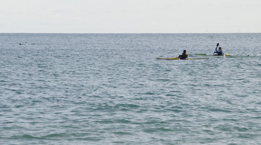 Traci Lynn Martin and Chris Stafford paddle north in Lake Huron Thursday, March 9, 2017 at Lighthouse Beach in Port Huron, Mich., for Traci's trip around the Great Lakes in 265 days. (Mark R. Rummel/The Times Herald via AP)