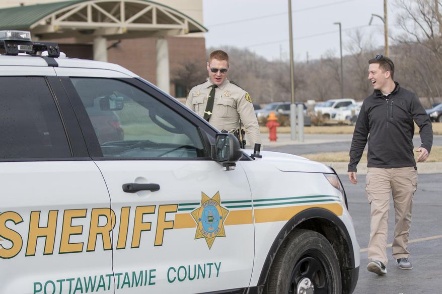 ADVANCE FOR USE SATURDAY, MARCH 11 - In this Friday, March 3, 2017 photo, Noah Hahn, right, a 19-year-old Lewis Central graduate and current junior at the University of Nebraska at Omaha majoring in criminal justice, prepares to ride along on a road patrol with Sheriff's Deputy Eric Shea in Council Bluffs, Iowa. Hoping to follow a career in law enforcement, Hahn is participating in an internship program through the Pottawattamie County Sheriff's Office. (Joe Shearer/The Daily Nonpareil via AP)