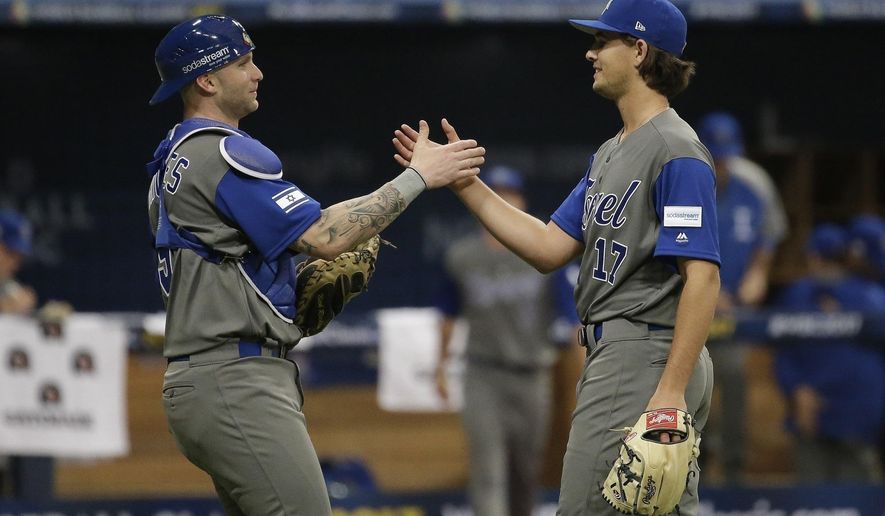FILE - In this March 7, 2017 file photo, Israel's pitcher Dean Kremer, right, celebrates his team's victory with catcher Nick Rickles against Taiwan after the first round game of the World Baseball Classic at Gocheok Sky Dome in Seoul, South Korea. Team Israel is tearing up the World Baseball Classic, upsetting a trio of top 10 teams and generating a buzz with their plucky play, colorful fans and unusual mascot. But back in their supposed homeland, no one seems to be taking notice in a country where the game has long been overlooked as arcane and boring. The current team, made up almost entirely of American pros of Jewish descent, has been derided as a group of mercenaries will little connection to the country. (AP Photo/Ahn Young-joon)