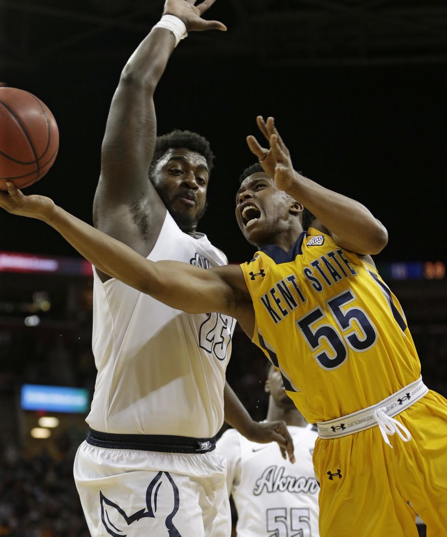Kent State's Kevin Zabo (55) drives past Akron's Isaiah Johnson (23) during the first half of an NCAA college basketball championship game of the Mid-American Conference tournament, Saturday, March 11, 2017, in Cleveland. (AP Photo/Tony Dejak)