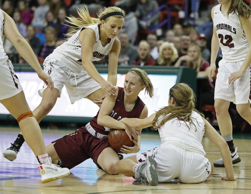 De Pere's Olivia DeCleene fights for possession of the ball with Middleton's Alexis Thomas, left, and Alyssa Lemirande during overtime in a semifinal in the WIAA girls' Division 1 state basketball championships Friday, March 10, 2017 in Green Bay, Wis. De Pere won 49-47 (AP Photo/Matt Ludtke)