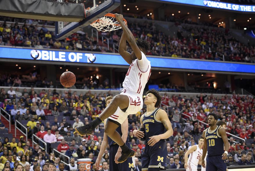 Wisconsin forward Nigel Hayes dunks in front of Michigan forward D.J. Wilson (5) and guard Derrick Walton Jr. (10) during the first half of an NCAA college basketball game for the Big Ten tournament title, Sunday, March 12, 2017, in Washington. (AP Photo/Nick Wass)