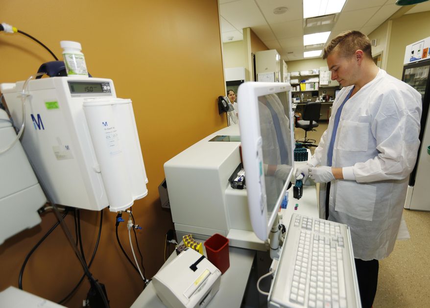In this Thursday, March 9, 2017, photograph, lab technician Zach Meili works in Denver Health Medical Center's primary care clinic located in a low-income neighborhood in southwest Denver. Under the new GOP health care proposal, which could roll back Medicaid expansion and take away subsidies to help pay for insurance, Denver Health could absorb a revenue loss, a problem that it will share with large public health systems across the country that serve low-income patients. (AP Photo/David Zalubowski)
