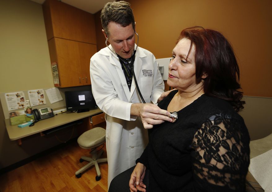 In this Thursday, March 9, 2017, photo, Dr. Michael Russum, left, checks patient Ruby Giron in Denver Health Medical Center's primary care clinic located in a low-income neighborhood in southwest Denver. Under the new GOP health care proposal, which could roll back Medicaid expansion and take away subsidies to help pay for insurance, Denver Health could absorb a revenue loss, a problem that it will share with large public health systems across the country that serve low-income patients. (AP Photo/David Zalubowski)