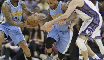 Denver Nuggets guard Jameer Nelson, center, runs between teammate Wilson Chandler, left, and Sacramento Kings center Kosta Koufos, right, to grab a loose ball during the first half of an NBA basketball game, Saturday, March 11, 2017, in Sacramento, Calif. (AP Photo/Rich Pedroncelli)