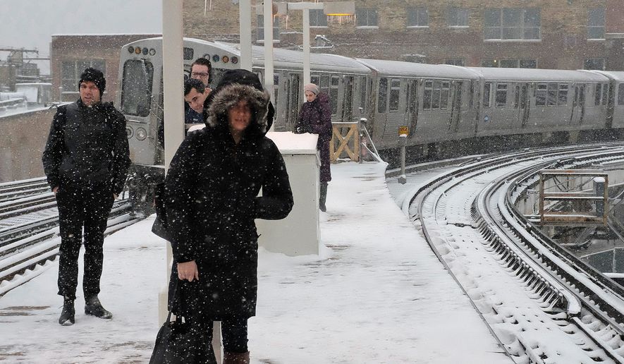 Commuters dealt with snowfall on Monday in Chicago, which had no accumulation in January and February for the first time in 146 years, according to the National Weather Service. The massive storm is disrupting travel in the Northeast. (Associated Press)