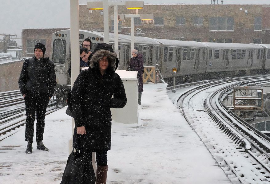 Commuters dealt with snowfall on Monday in Chicago, which had no accumulation in January and February for the first time in 146 years, according to the National Weather Service. The massive storm is disrupting travel in the Northeast. (Associated Press)