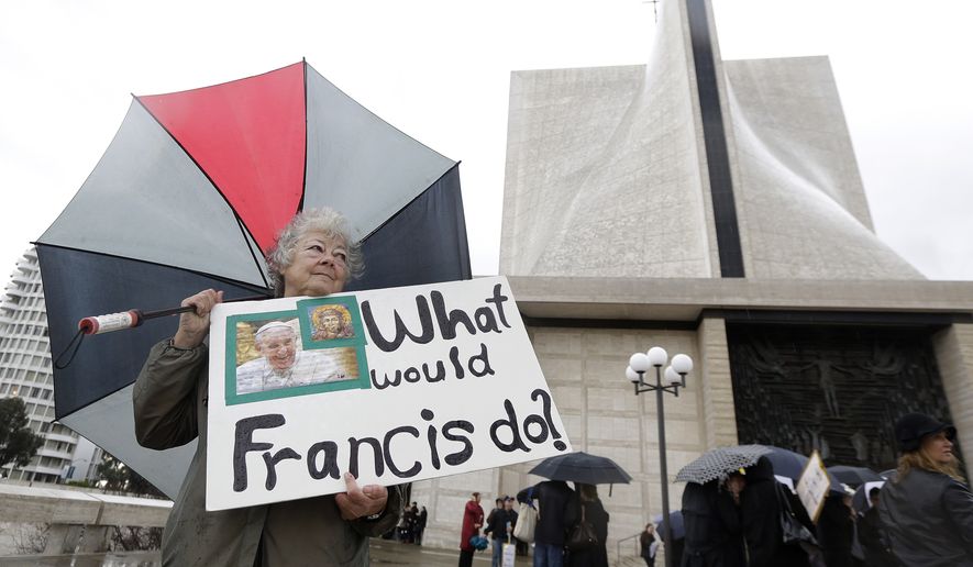 Marti Kashuba holds up a sign outside of St. Mary's Cathedral in San Francisco, Friday, Feb. 6, 2015. The Roman Catholic archbishop of San Francisco is getting pushback from some parents, students and teachers at parochial schools after unveiling faculty handbook language calling on teachers to lead their public and professional lives consistently with church teachings on homosexuality, same-sex marriage, abortion, birth control and other behaviors he describes as evil. (AP Photo/Jeff Chiu) **FILE**