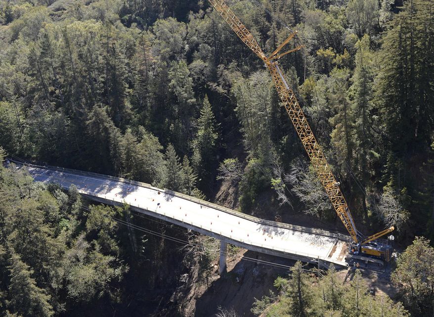 Construction crews use a wrecking ball to dismantle the Pfeiffer Canyon Bridge on Highway 1 Monday, March 13, 2017, in Big Sur, Calif. The bridge was compromised after slides occurred in the area associated with this winter's heavy rains. (David Royal/Monterey Herald via AP)