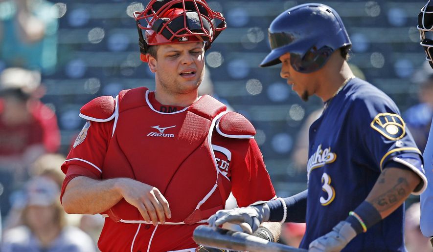Cincinnati Reds catcher Devin Mesoraco, left, talks with Brewers shortstop Orlando Arcia (3) at home plate during the first inning of a spring training baseball game Sunday, March 12, 2017, in Goodyear, Ariz. The Reds defeated the Brewers 4-2. (AP Photo/Ross D. Franklin)