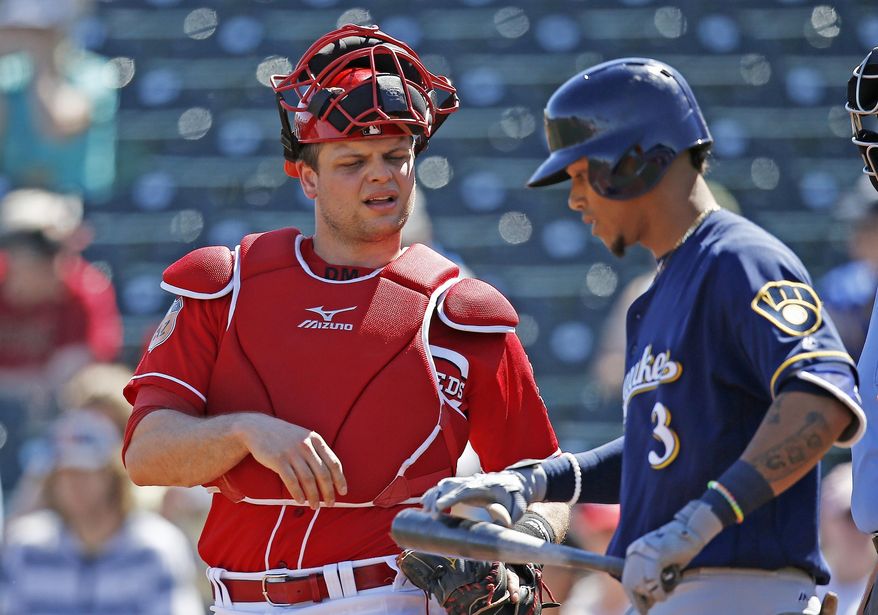 Cincinnati Reds catcher Devin Mesoraco, left, talks with Brewers shortstop Orlando Arcia (3) at home plate during the first inning of a spring training baseball game Sunday, March 12, 2017, in Goodyear, Ariz. The Reds defeated the Brewers 4-2. (AP Photo/Ross D. Franklin)