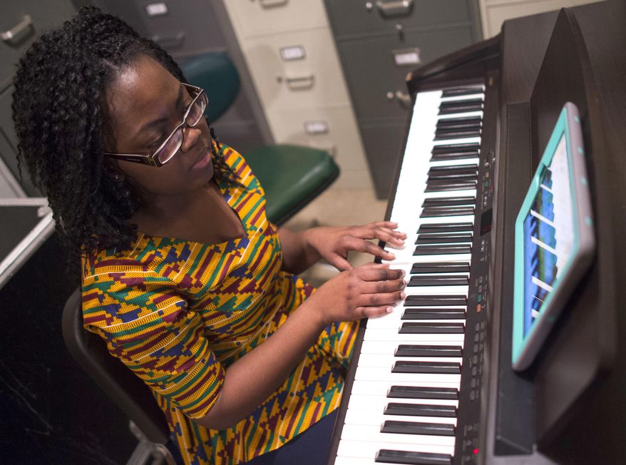 In this Feb. 11, 2017 photo, exchange student Abigail Adusei practices the piano during class at Manual Academy, in Peoria, Ill. "Being an exchange student I've been able to learn different cultures and things much different from what I was used to," said Adusei, who is a foreign exchange student from Ghana. "Really all I knew about culture in the United States was what we saw in the movies, and Manual High isn't anything like what I saw in High School Musical." (Ryan Michalesko/Journal Star via AP)