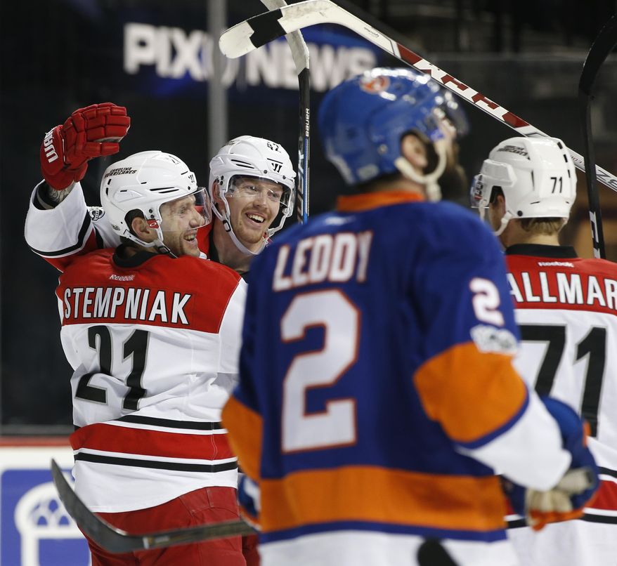 Carolina Hurricanes left wing Joakim Nordstrom (42), of Sweden, celebrates with Hurricanes right wing Lee Stempniak (21) and Hurricanes center Lucas Wallmark (71) of Sweden after scoring during the first period of an NHL hockey game against the New York Islanders, Monday, March 13, 2017, in New York. New York Islanders defenseman Nick Leddy (2)skates past the celebration. (AP Photo/Kathy Willens)