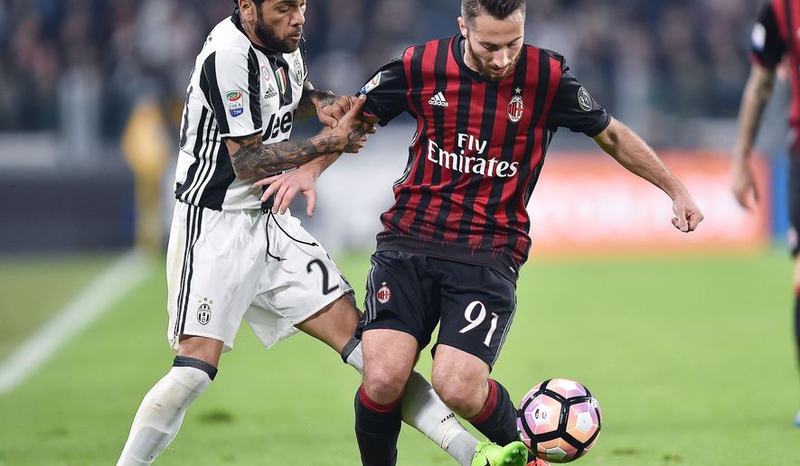 Juventus&#39; Dani Alves, left, and Milan&#39;s Andrea Bertolacci vie for the ball during the Italian Serie A soccer match between Juventus and Milan at the Juventus stadium in Turin, Italy, Friday, March 10, 2017. (Alessandro Di Marco/ANSA via AP)