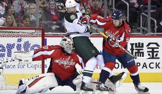 Minnesota Wild center Eric Staal (12) gets stuck between Washington Capitals goalie Braden Holtby (70) and defenseman Dmitry Orlov (9), of Russia, during the first period of an NHL hockey game, Tuesday, March 14, 2017, in Washington. (AP Photo/Nick Wass)