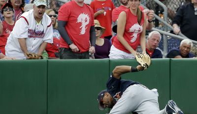 Fans react as Atlanta Braves outfielder Micah Johnson rolls after diving to catch a fly ball in the sixth inning in a spring training baseball game against the Philadelphia Phillies, Tuesday, March 14, 2017, in Clearwater, Fla. (AP Photo/John Raoux)