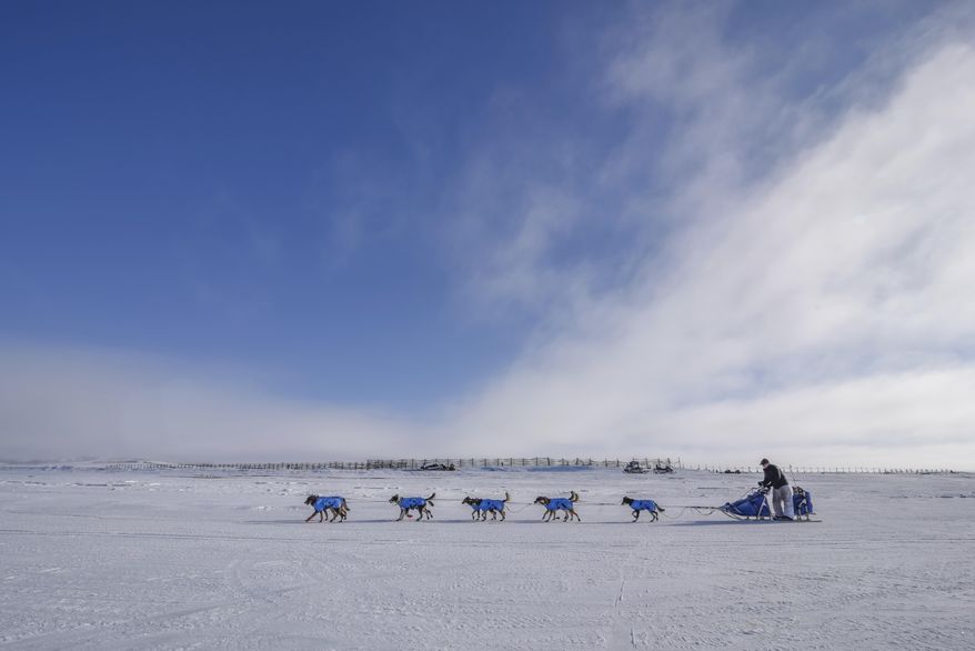 In this photo provided by the Iditarod Trail Committee, veteran musher Scott Smith and his race team travel along the frozen Kouwegok River out of Unalakleet, Alaska, toward the Shaktoolik checkpoint Monday, March 13, 2017. Mushers and their race teams competing in Iditarod XLV are now past the halfway point of the race and heading into the final push on the trek to Nome. (Mike Kenney/Iditarod Trail Committee via AP)