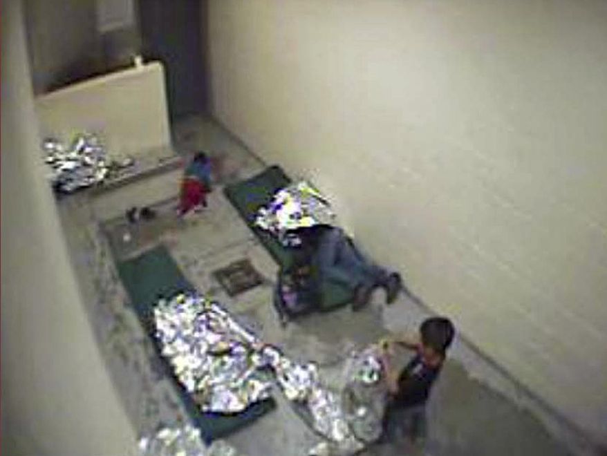 FILE- This September, 2015 file image made from U.S. Border Patrol surveillance video shows a child crawling on the concrete floor near the bathroom area of a holding cell, and a woman and children wrapped in Mylar sheets at a U.S. Customs and Border Protection station in Douglas, Ariz. A federal judge says the Border Patrol in Arizona violated court orders by failing to properly keep surveillance video pertaining to a lawsuit claiming the agency holds migrants in inhumane conditions. Judge David Bury partially granted a motion on Monday, March 13, to hold the Border Patrol's Tucson Sector in civil contempt over video files it was legally required to provide but which were irreparably damaged.(U.S. Border Patrol via AP, File)
