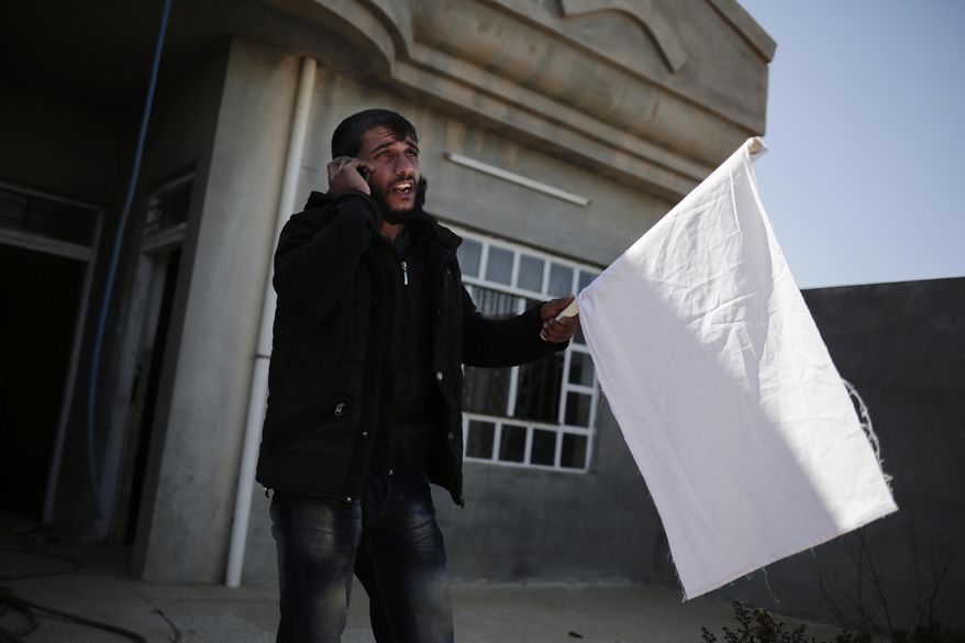 FILE - On this Feb. 21, 2017 file photo, a civilian who escaped Islamic State territory phones his family he left behind in Abu Saif, Iraq. Some 40 square kilometers on the western bank of the Tigris River is the Islamic State group’s last major stand in Iraq. In addition to Mosul’s so-called right bank, IS still controls a handful of small pockets of Iraqi territory and a swath of Syria’s north including the group’s self-proclaimed capital, Raqqa.(AP Photo/Bram Janssen, File)