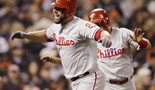 FILE- In this June 25, 2016, file photo, Philadelphia Phillies' Cameron Rupp, left, celebrates after hitting a two-run home run against the San Francisco Giants during the seventh inning of a baseball game in San Francisco. Rupp is a fan favorite in Philadelphia until football season starts. Rupp grew up in Dallas and loves the Cowboys. That doesn't sit well in Philly where Eagles fans are obsessed with hating America's Team. (AP Photo/Marcio Jose Sanchez, File)