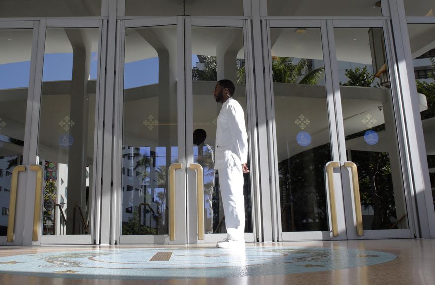 In this Tuesday, Feb. 14, 2017 photo, a doorman stands at the entrance to the Faena Hotel in Miami Beach, Fla. The beachfront hotel is the flagship of Faena District, a cluster of buildings developed by Argentine hotel magnate Alan Faena where decaying structures and empty parking lots are giving way to opulent hotels, condos, and a performing arts center. (AP Photo/Lynne Sladky)