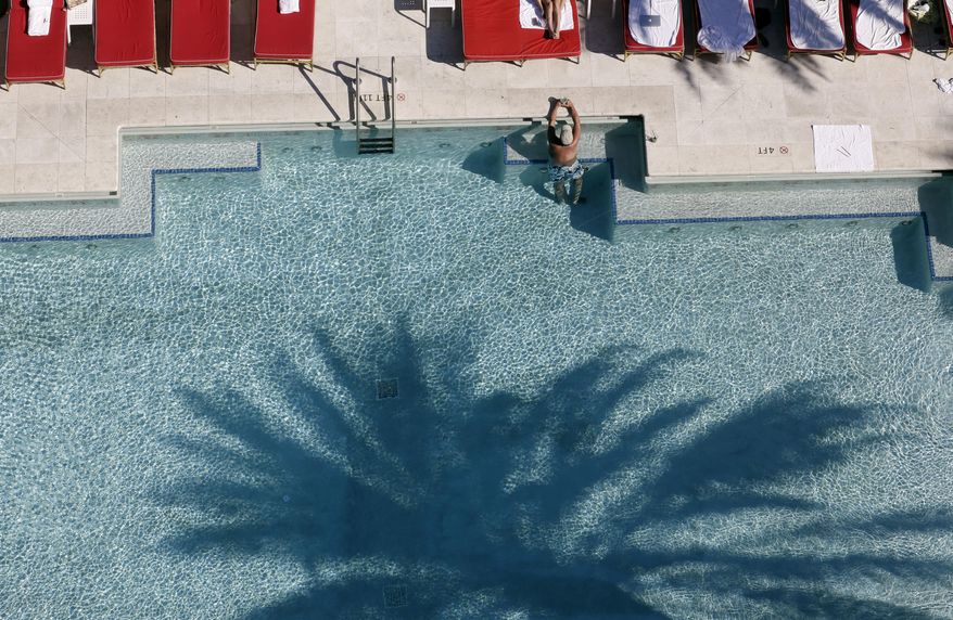 In this Tuesday, Feb. 14, 2017 photo, the shadow of a palm tree is shown on the swimming pool at the Faena Hotel in Miami Beach, Fla. The beachfront hotel is the flagship of Faena District, a cluster of buildings developed by Argentine hotel magnate Alan Faena where decaying structures and empty parking lots are giving way to opulent hotels, condos, and a performing arts center. (AP Photo/Lynne Sladky)
