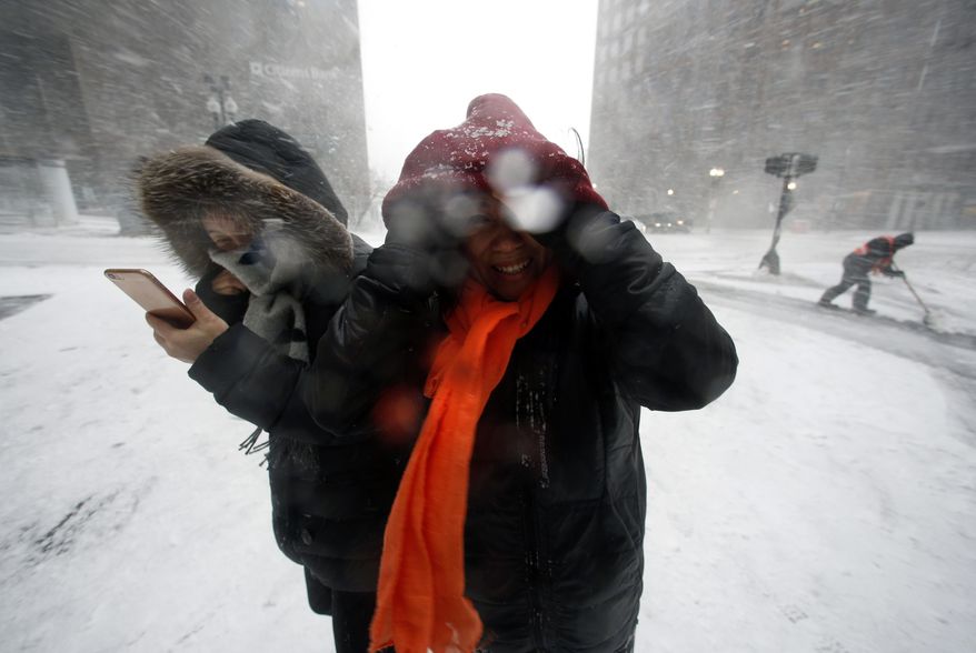 People walk in the wind-driven snow during a winter storm Tuesday, March 14, 2017, in Boston. (AP Photo/Michael Dwyer)