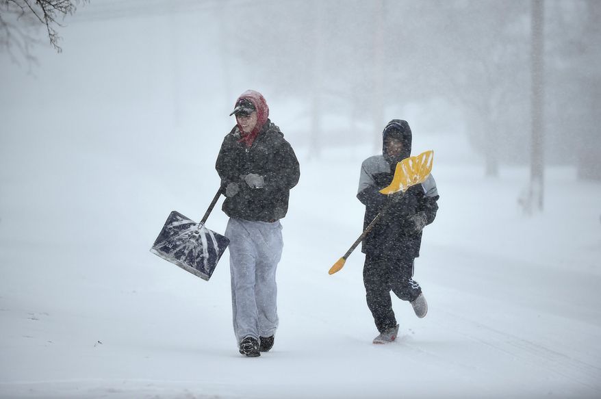 Austin Diaz, left, and Tresor Russell, right, run up Warwick Street as they hunt for customers in need of shoveling Tuesday, March 14, 2017. The two had the day off from Middletown High School and were shoveling for a few repeat customers as well as looking for new ones. "When we knock on doors most people ask us to come back later when the storm is almost over," said Diaz. (Cloe Poisson/Hartford Courant via AP)