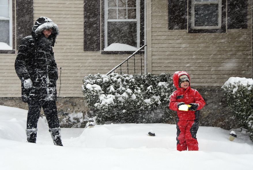 Michelle Fleming and her son Tyler play outside in the latest snow storm on Spruce Street in Bristol, Conn., on Tuesday, March 14, 2017. (Mike Orazzi/The Bristol Press via AP)