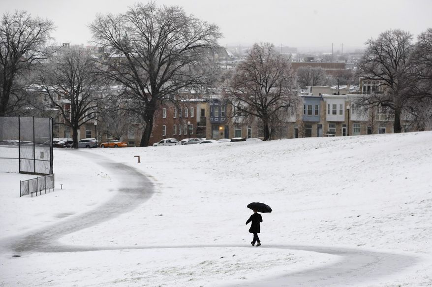A man walks through a park in Baltimore, Tuesday, March 14, 2017, as a winter storm moves through the region. (AP Photo/Patrick Semansky)