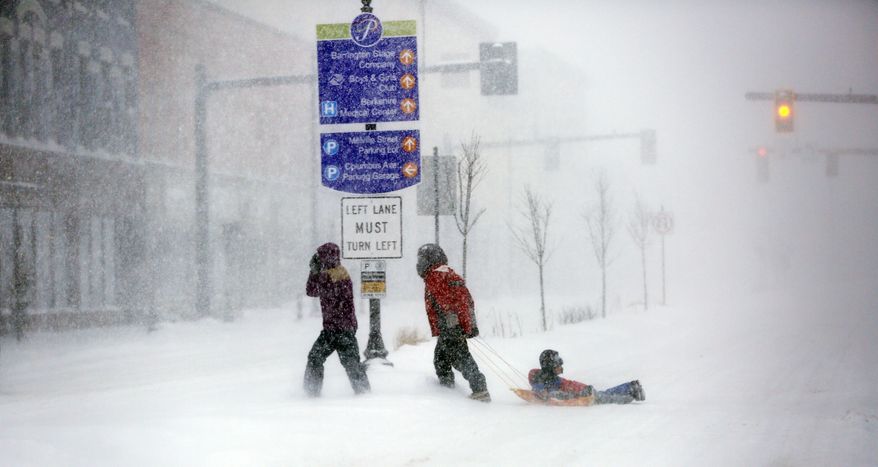 Walkers make their way through the snow-filled streets of Pittsfield, Mass., Tuesday, March 14, 2017. (Stephanie Zollshan/The Berkshire Eagle via AP)