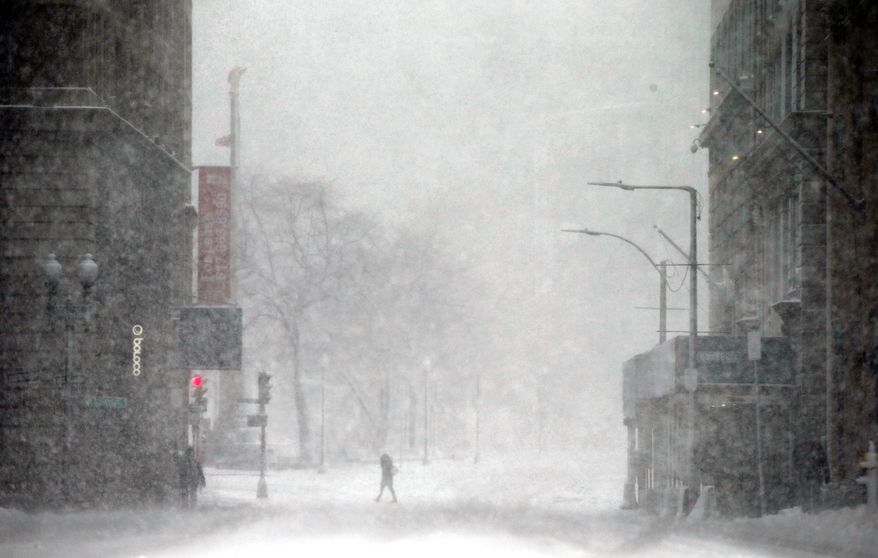 A person crosses a street in blowing snow during a winter storm Tuesday, March 14, 2017, in Boston. (AP Photo/Michael Dwyer)