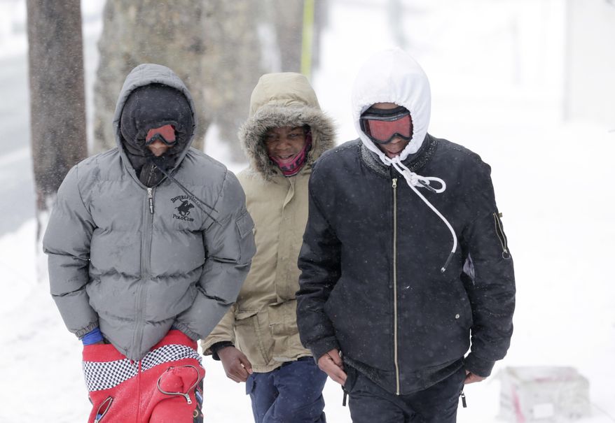 Jalen Mitchell, center, walks with his brothers Umar Johnson, left, and Manel Smith, who use ski googles, as they make their way through the sleet in Newark, N.J., Tuesday, March 14, 2017. A storm pounded the Northeast with more than a foot of snow in places Tuesday, paralyzing much of the Washington-to-Boston corridor after a remarkably mild February had lulled people into thinking the worst of winter was over. (AP Photo/Seth Wenig)