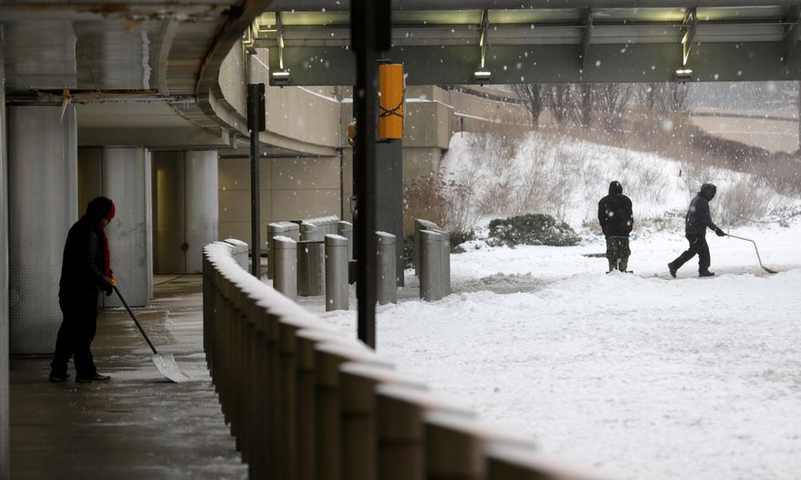 People shovel snow at Newark Liberty International Airport in Newark, N.J., Tuesday, March 14, 2017. A storm pounded the Northeast with more than a foot of snow in places Tuesday, paralyzing much of the Washington-to-Boston corridor after a remarkably mild February had lulled people into thinking the worst of winter was over. (AP Photo/Seth Wenig)