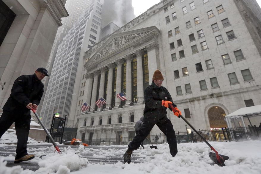 Snow is shoveled from a sidewalk adjacent to the New York Stock Exchange, Tuesday, March 14, 2017. New York Gov. Andrew Cuomo has declared a state of emergency Tuesday for all of New York's 62 counties, including New York City's five boroughs. (AP Photo/Richard Drew)