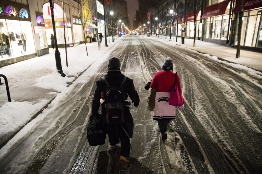 A couple walks in the street during a winter storm in Philadelphia, Tuesday, March 14, 2017. (AP Photo/Matt Rourke)