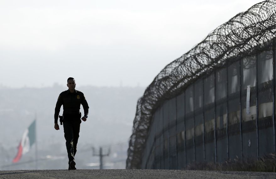 Border Patrol agent Eduardo Olmos walks near the secondary fence separating Tijuana, Mexico, background, and San Diego in San Diego in June 2016. The Inter-American Commission on Human Rights, an arm of the Organization of American States, has said it will fight against President Trump&#x27;s immigration plans. The group has accused him of fostering an “enormous human rights crisis.&quot;