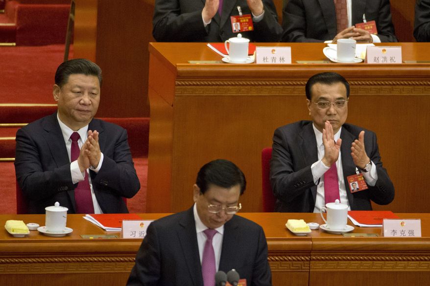 Chinese President Xi Jinping, left and Chinese Premier Li Keqiang, right, applaud during the closing session of the National People's Congress held in the Great Hall of the People in Beijing, China, Wednesday, March 15, 2017. (AP Photo/Ng Han Guan)